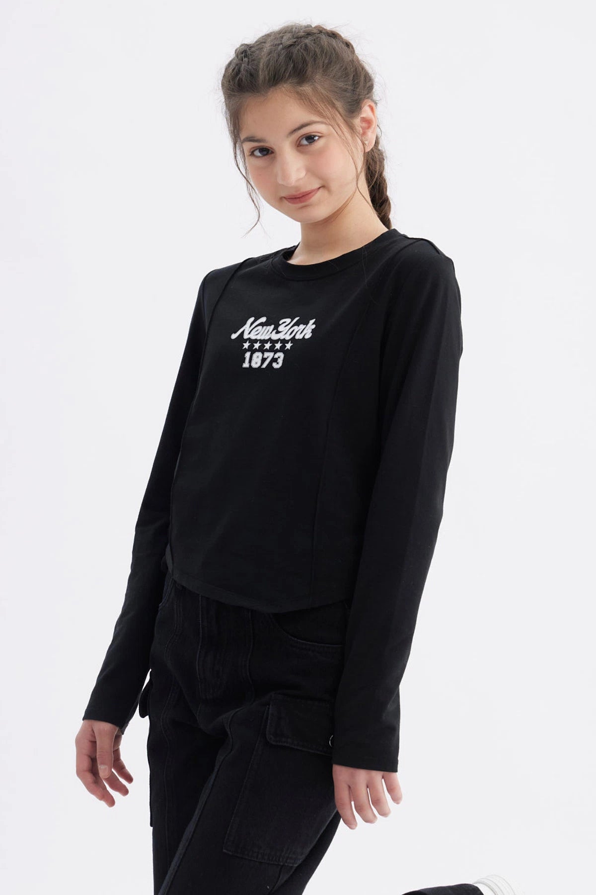 Polera niña slim negra con diseño frontal de letras blancas New York 1873 casual y moderna ideal para uso diario