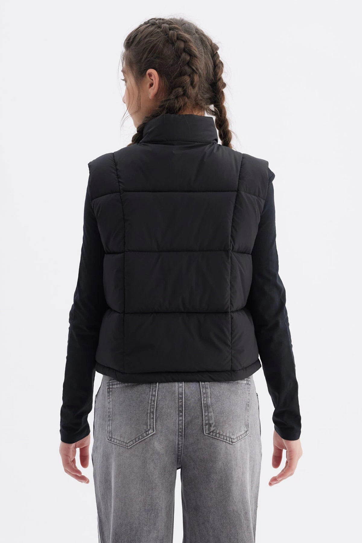 Chaleco negro para niña con diseño acolchado y cierre frontal prenda lisa sin estampas