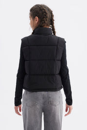 Chaleco negro para niña con diseño acolchado y cierre frontal prenda lisa sin estampas