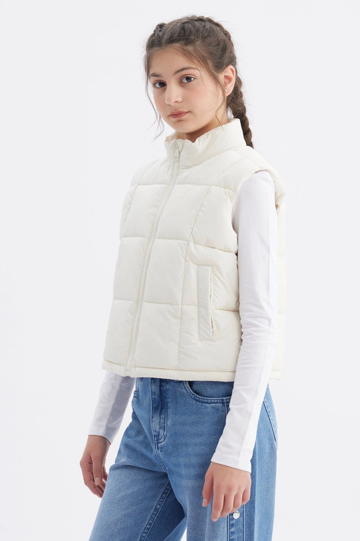Chaleco acolchado crudo para niña con cuello alto y cierre frontal liso ideal para el invierno