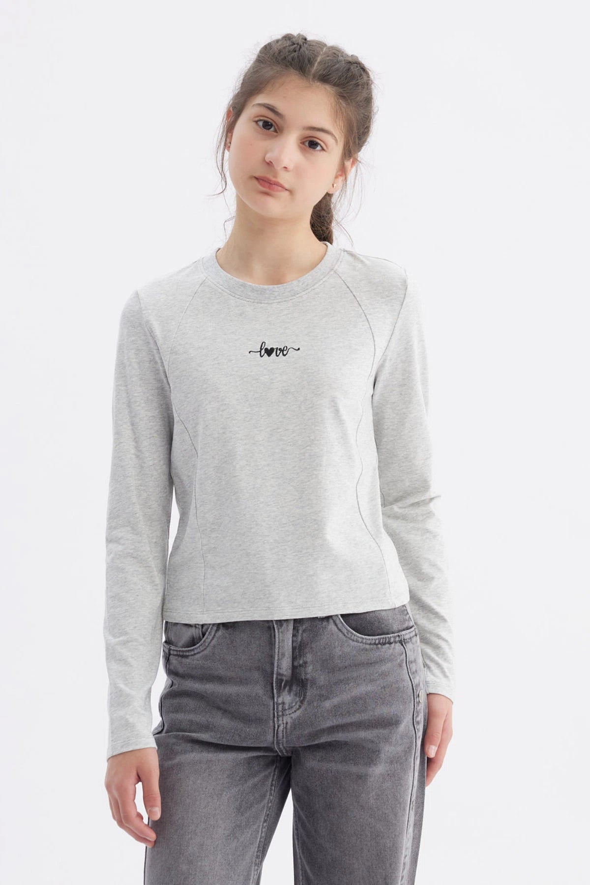Polera gris melange para niña con costuras visibles y la palabra love en el pecho en letra cursiva negra