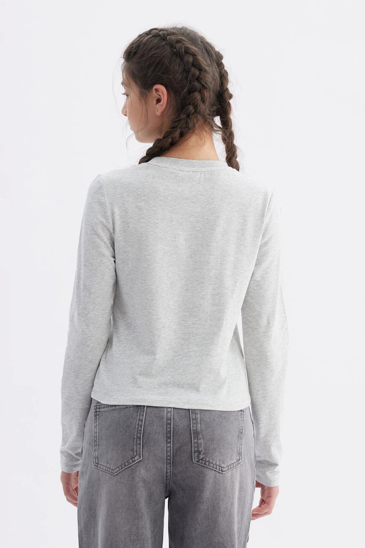 Polera gris melange para niña con costuras visibles y la palabra love en el pecho en letra cursiva negra