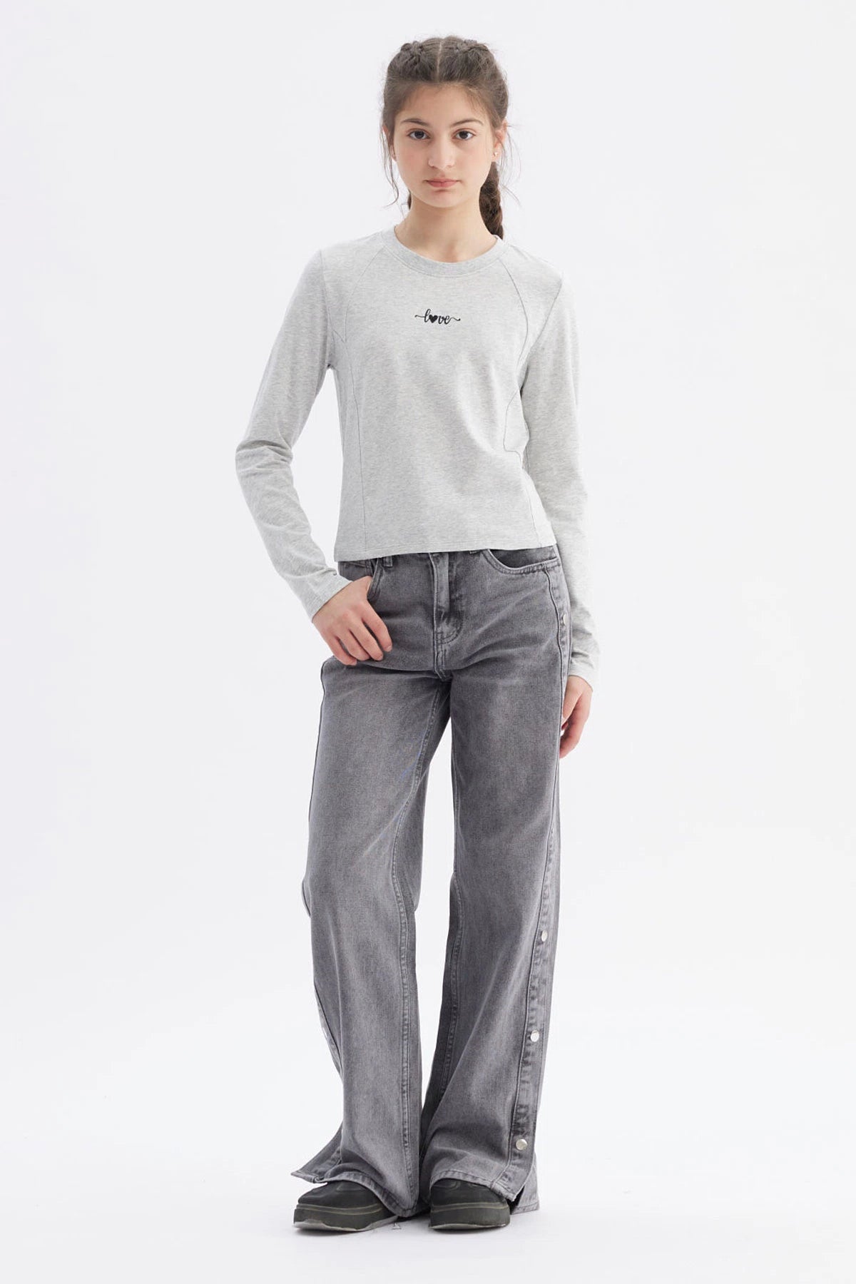 Polera gris melange para niña con costuras visibles y la palabra love en el pecho en letra cursiva negra