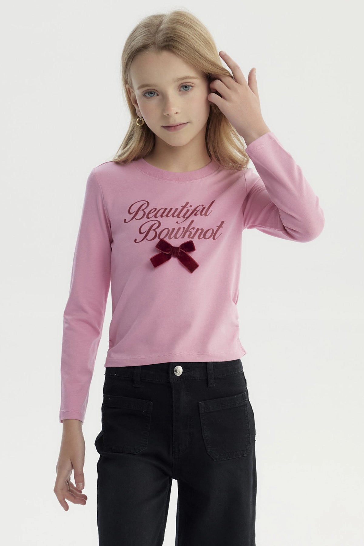 Polera slim rosada para niña con texto Beautiful Bowknot y lazo de terciopelo en el pecho estilo casual y juvenil