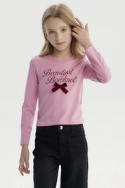 Polera slim rosada para niña con texto Beautiful Bowknot y lazo de terciopelo en el pecho estilo casual y juvenil