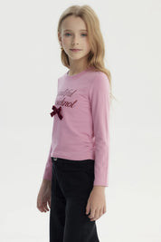 Polera slim rosada para niña con texto Beautiful Bowknot y lazo de terciopelo en el pecho estilo casual y juvenil