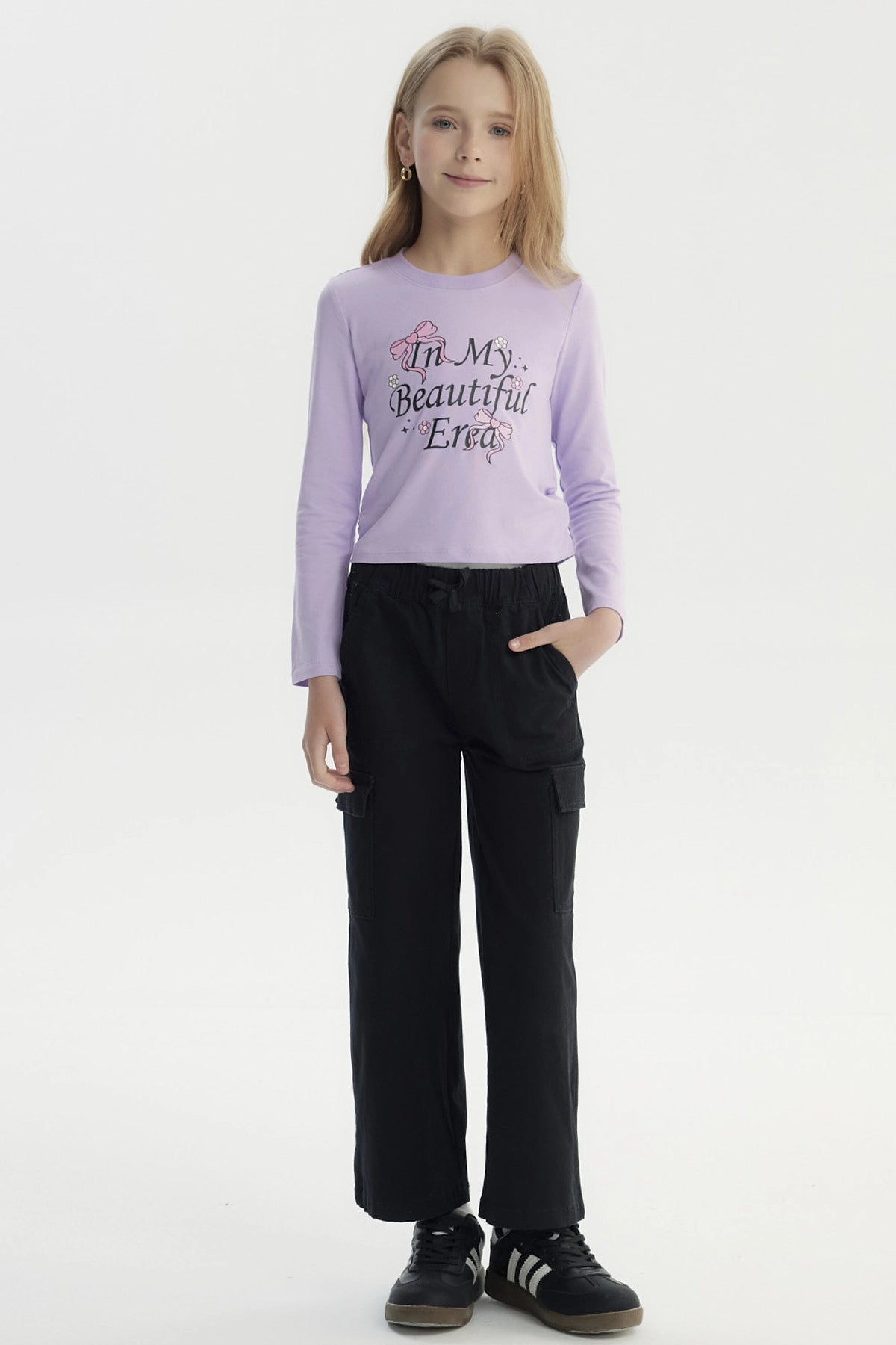 Polera slim lila para niña con estampa frontal de texto In My Beautiful Era y lazos rosados diseño floral