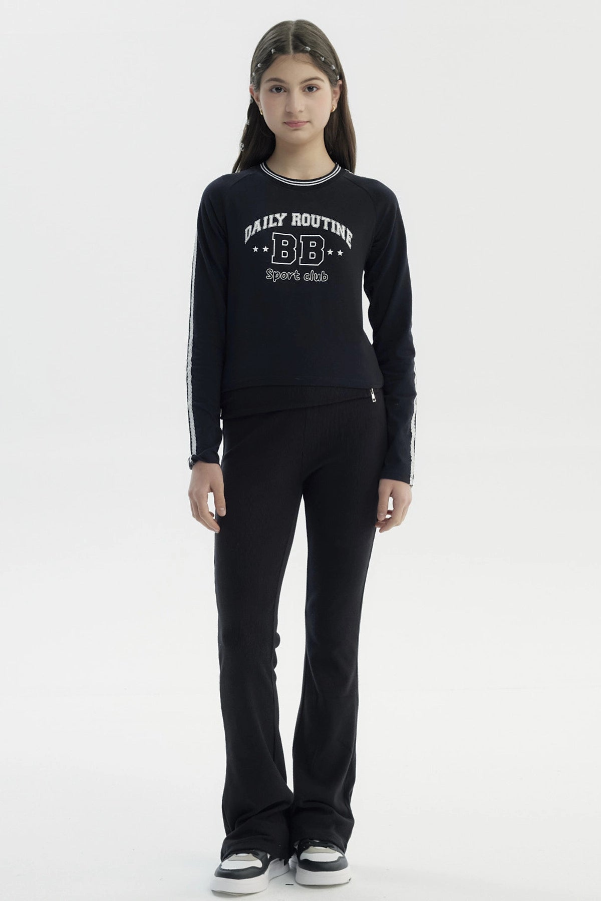 Polera negra para niña con diseño "DAILY ROUTINE BB Sport club" en el pecho estilo casual con líneas en las mangas