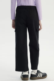 Pantalón recto negro para niña con bolsillos laterales grandes diseño liso