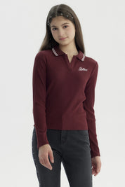Polera de niña burdeo con escote en V y cuello con rayas blancas diseño de texto 'Believe' en el pecho estilo casual