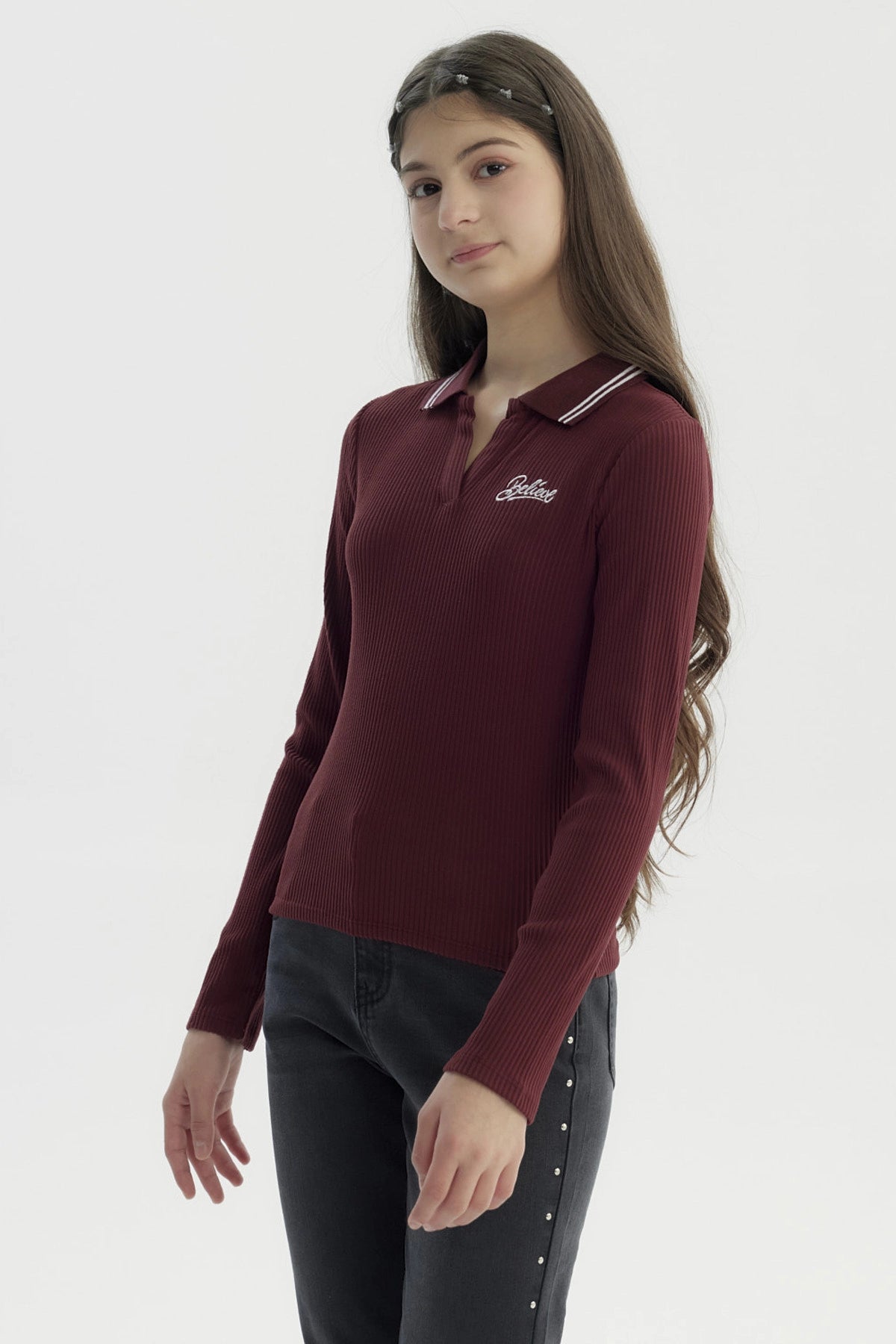 Polera de niña burdeo con escote en V y cuello con rayas blancas diseño de texto 'Believe' en el pecho estilo casual