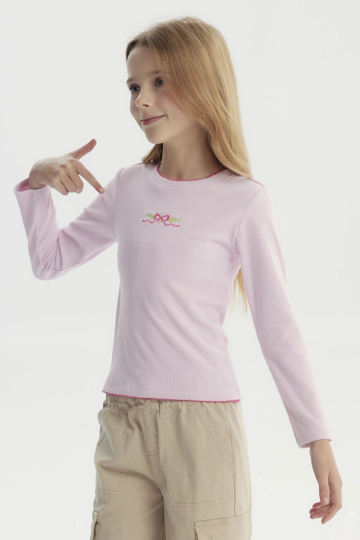 Polera slim rosada para niña con lazo bordado pequeño en el pecho estilo minimalista manga larga