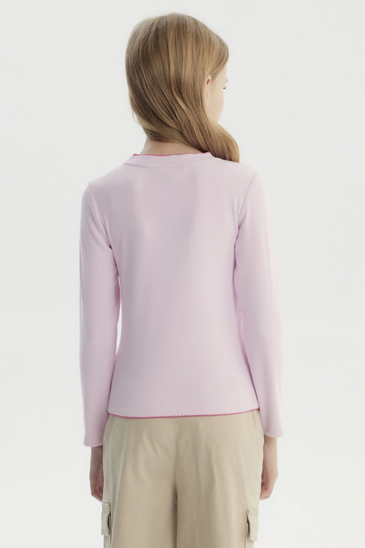 Polera slim rosada para niña con lazo bordado pequeño en el pecho estilo minimalista manga larga