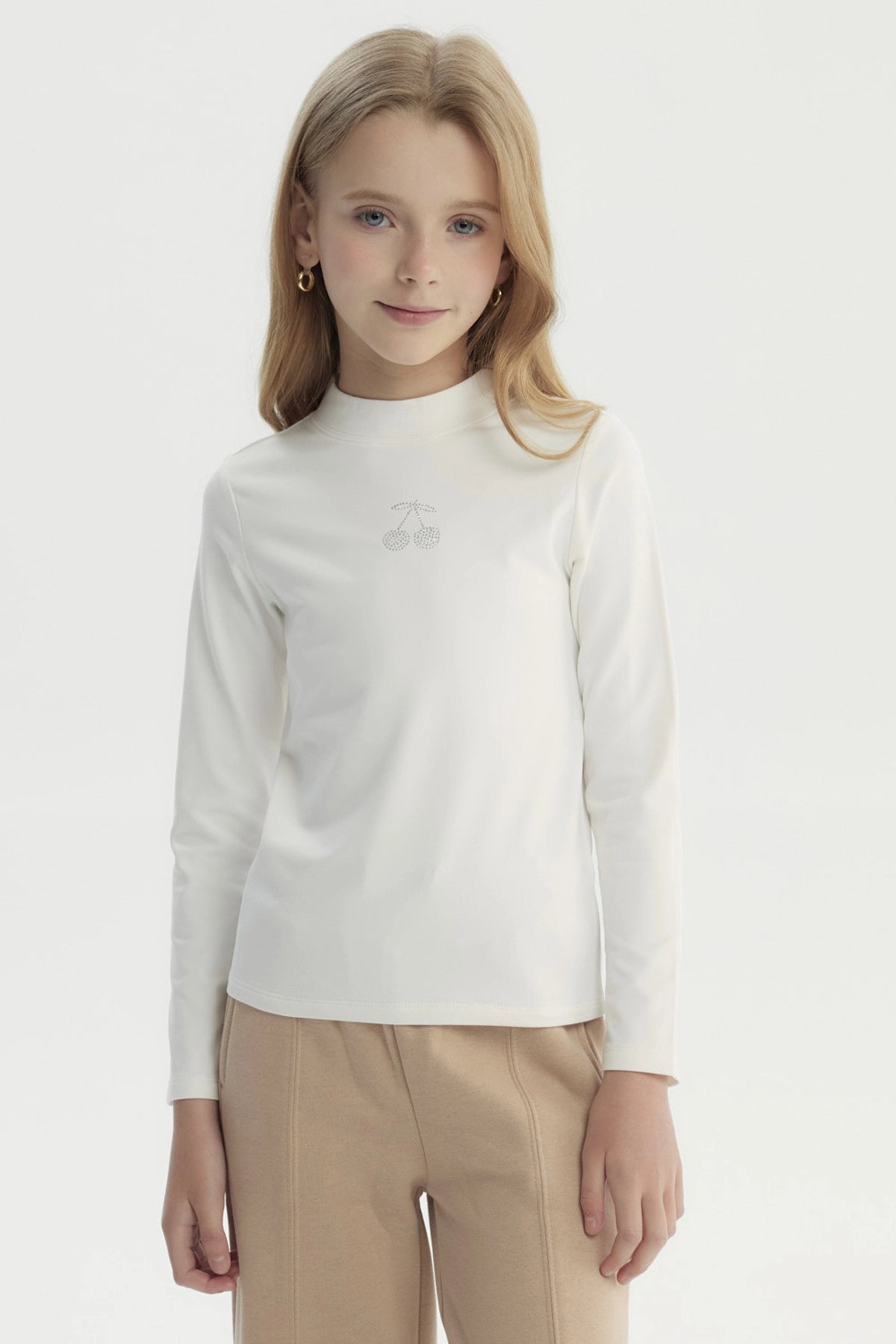 Polera niña slim crudo con estampado de cerezas pequeñas en el centro estilo minimalista lisa