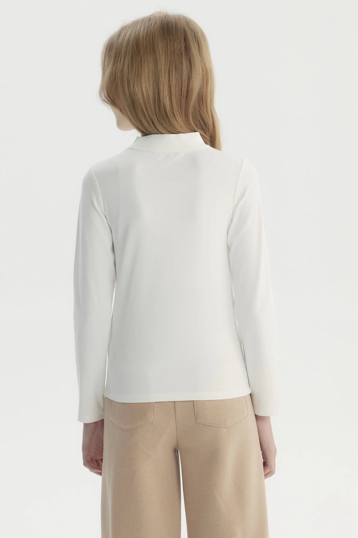 Polera niña slim crudo con estampado de cerezas pequeñas en el centro estilo minimalista lisa