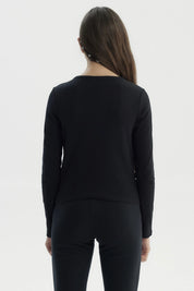 Polera ajustada negra para niña con texto 'Kindly' en el pecho en estilo cursivo pequeña estampa blanca sin más detalles