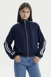 Chaqueta azul marino para niña con cierre y cuello alto detalles de líneas blancas en las mangas diseño deportivo liso
