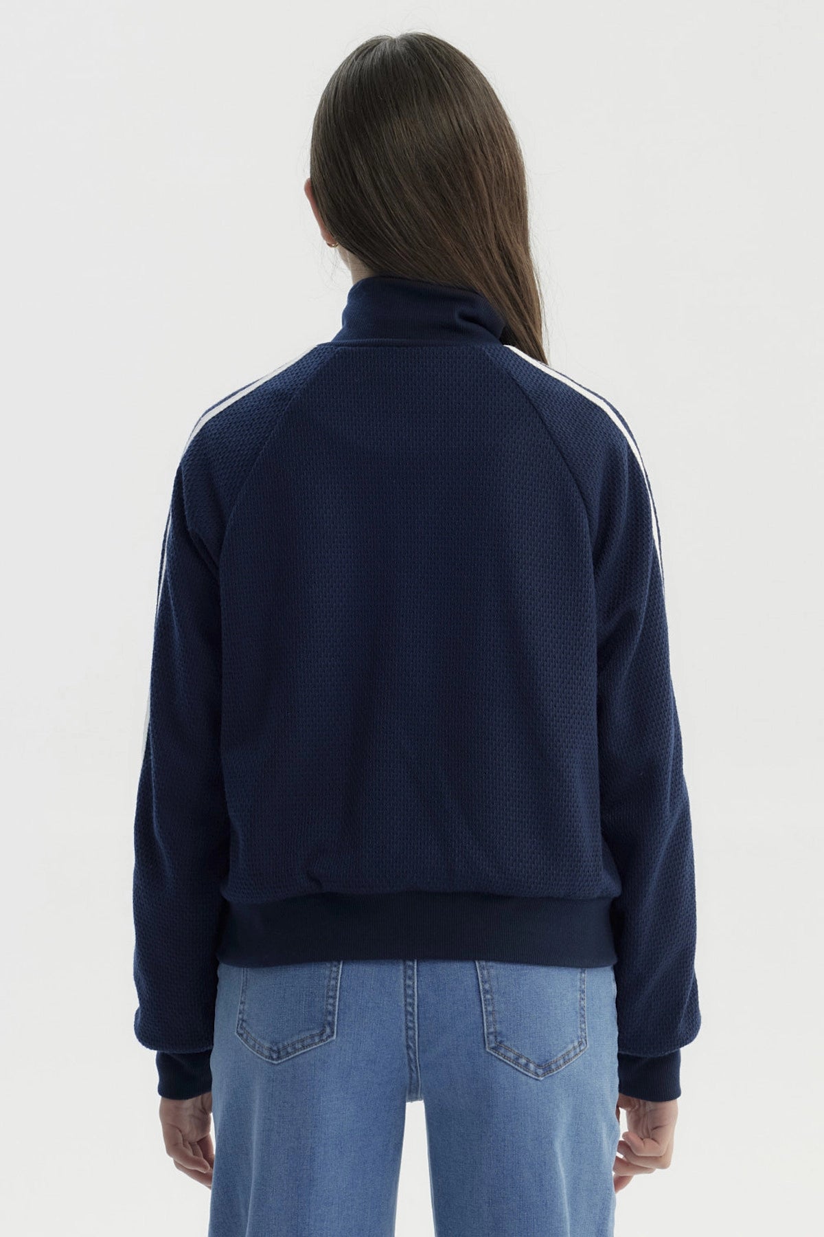 Chaqueta azul marino para niña con cierre y cuello alto detalles de líneas blancas en las mangas diseño deportivo liso