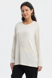 Polera slim crema para mujer con detalles de tachuelas doradas en el frente prenda lisa y elegante
