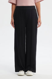 Pantalón buzo negro mujer calce recto con ojales decorativos en los costados diseño liso
