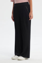 Pantalón buzo negro mujer calce recto con ojales decorativos en los costados diseño liso