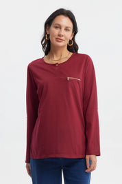 Polera roja de manga larga con cierre decorativo en el pecho prenda lisa ideal para días frescos
