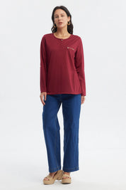 Polera roja de manga larga con cierre decorativo en el pecho prenda lisa ideal para días frescos