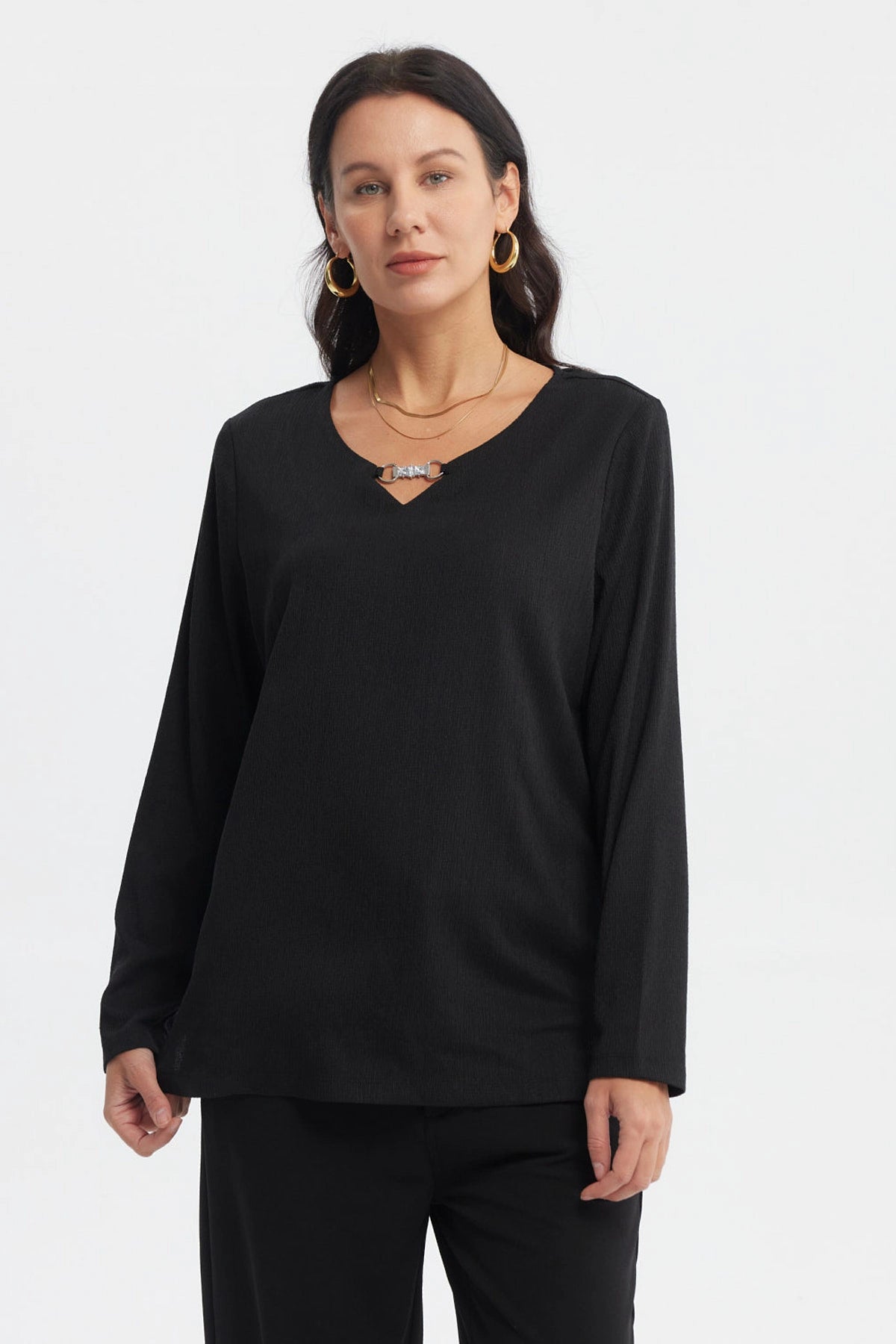 Polera negra de mujer con detalle metálico en el cuello escote en V manga larga y diseño liso elegante