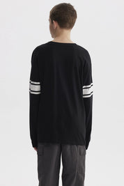 Polera negra de niño con franjas blancas en mangas y estampa colorida de texto 'Never Look Back' en el pecho