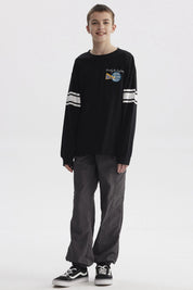Polera negra de niño con franjas blancas en mangas y estampa colorida de texto 'Never Look Back' en el pecho