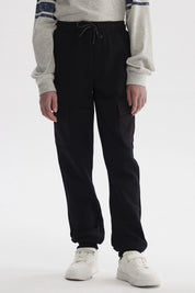 Pantalón jogger cargo negro para niño con bolsillos laterales y cordón ajustable estilo casual sin estampa visible