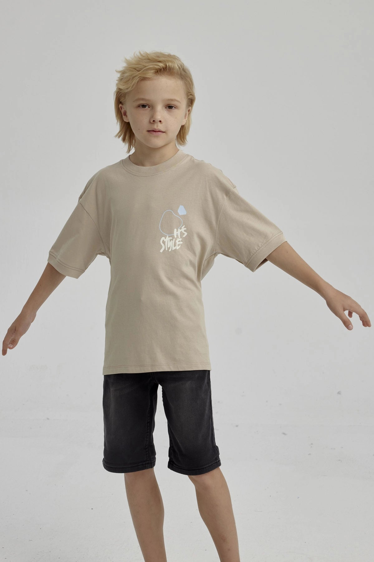 Polera de niño kaki con diseño gráfico abstracto en el pecho estilo urbano y mangas cortas ideal para días de juego