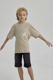 Polera de niño kaki con diseño gráfico abstracto en el pecho estilo urbano y mangas cortas ideal para días de juego