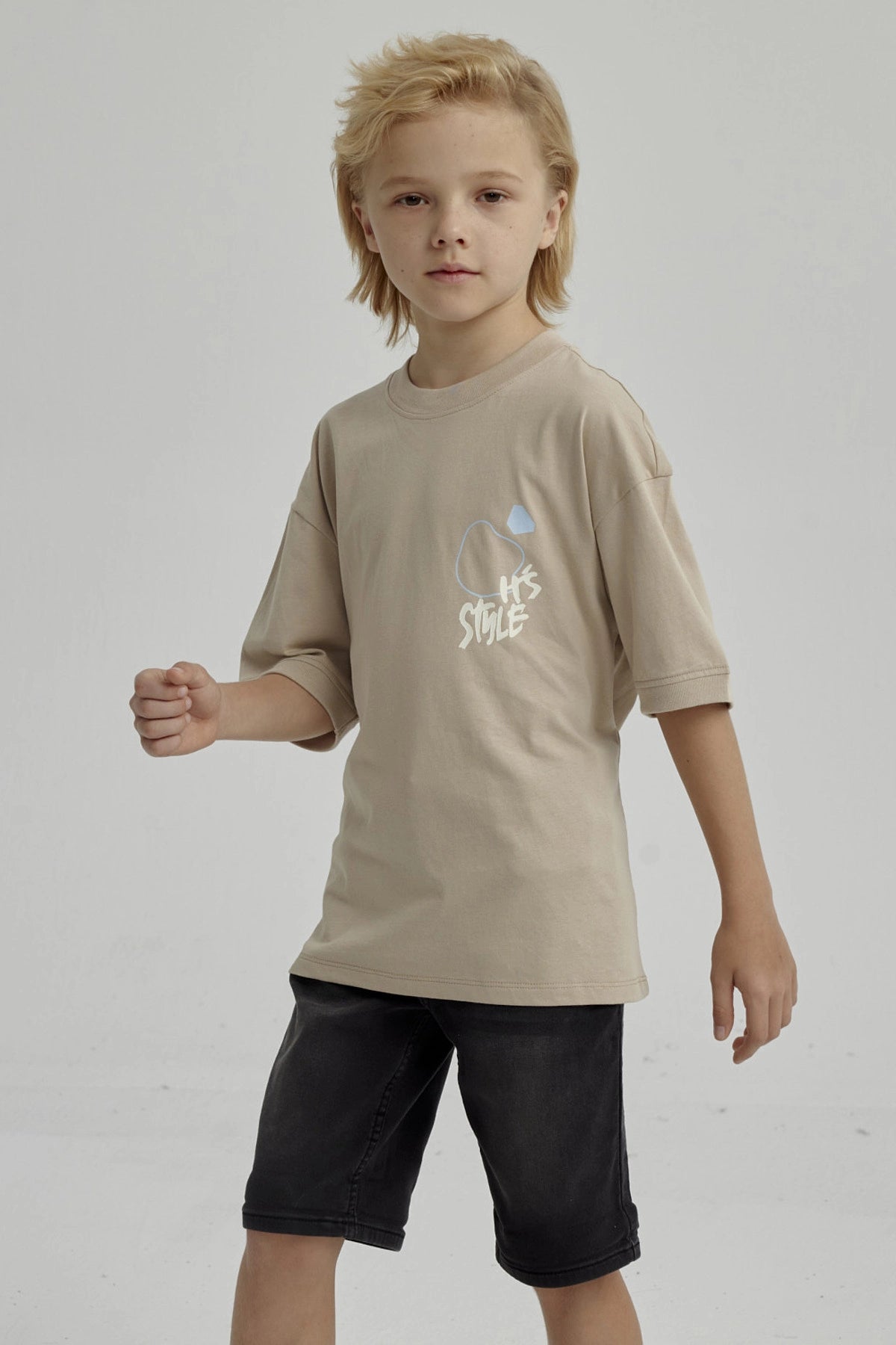 Polera de niño kaki con diseño gráfico abstracto en el pecho estilo urbano y mangas cortas ideal para días de juego
