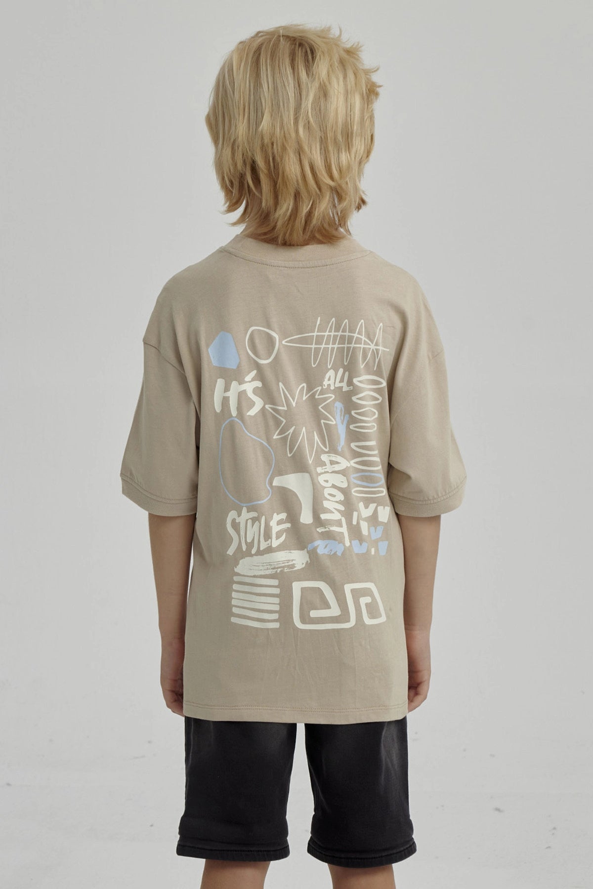 Polera de niño kaki con diseño gráfico abstracto en el pecho estilo urbano y mangas cortas ideal para días de juego