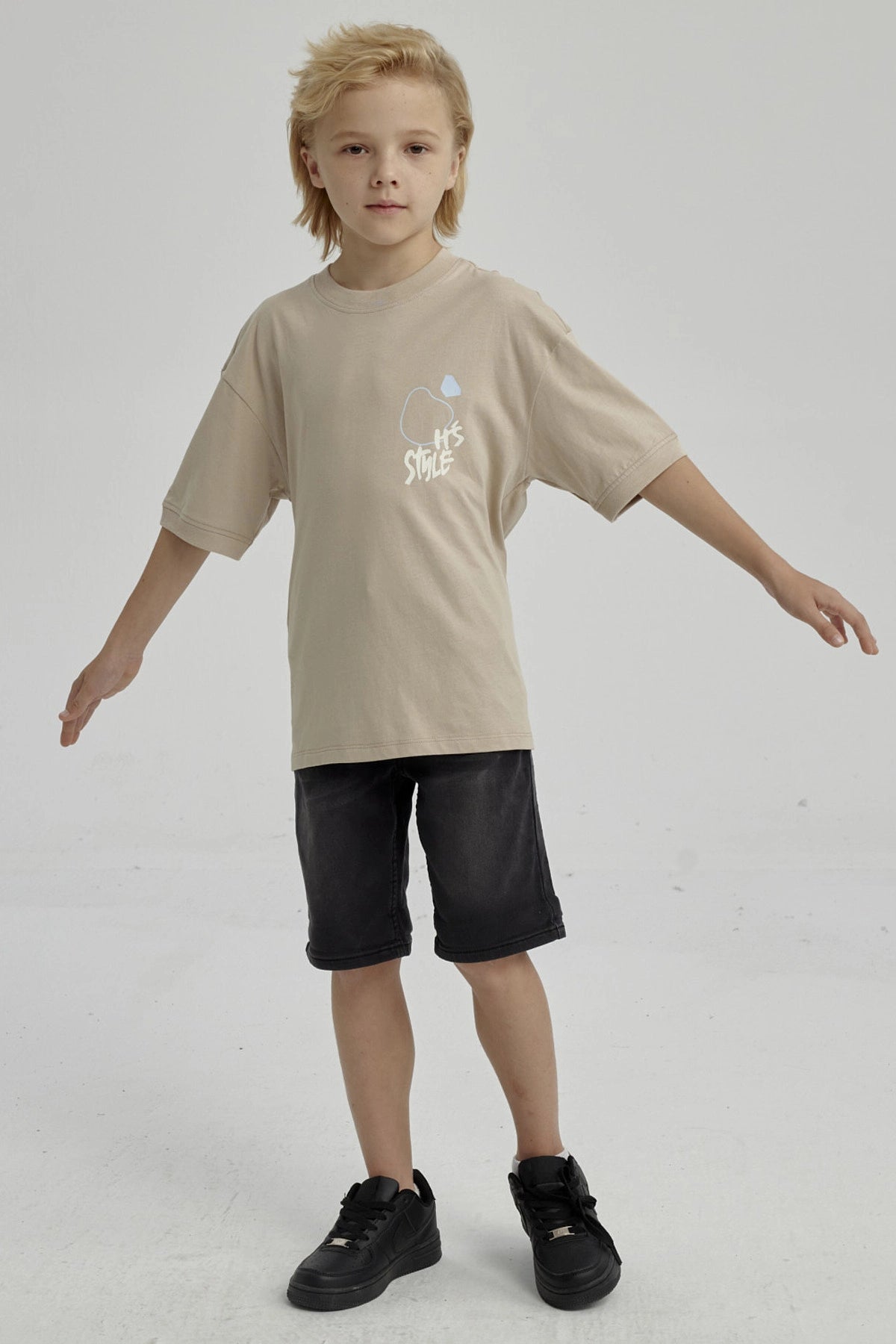 Polera de niño kaki con diseño gráfico abstracto en el pecho estilo urbano y mangas cortas ideal para días de juego