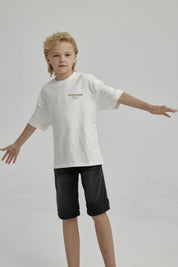 Polera de niño crudo con texto 'ESTABLISHED MONACO' en el pecho diseño sencillo y moderno de algodón sin estampa adicional