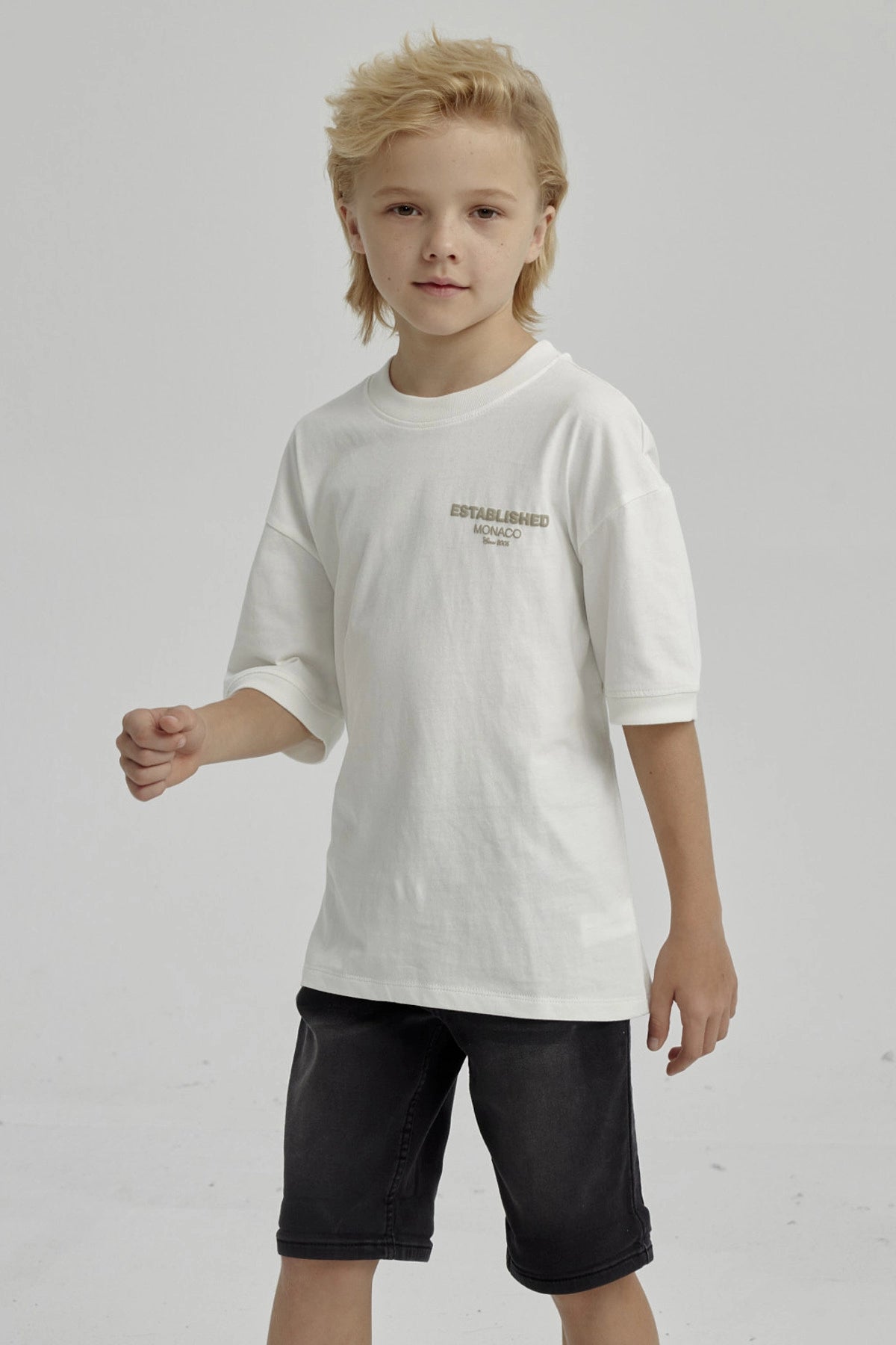Polera de niño crudo con texto 'ESTABLISHED MONACO' en el pecho diseño sencillo y moderno de algodón sin estampa adicional