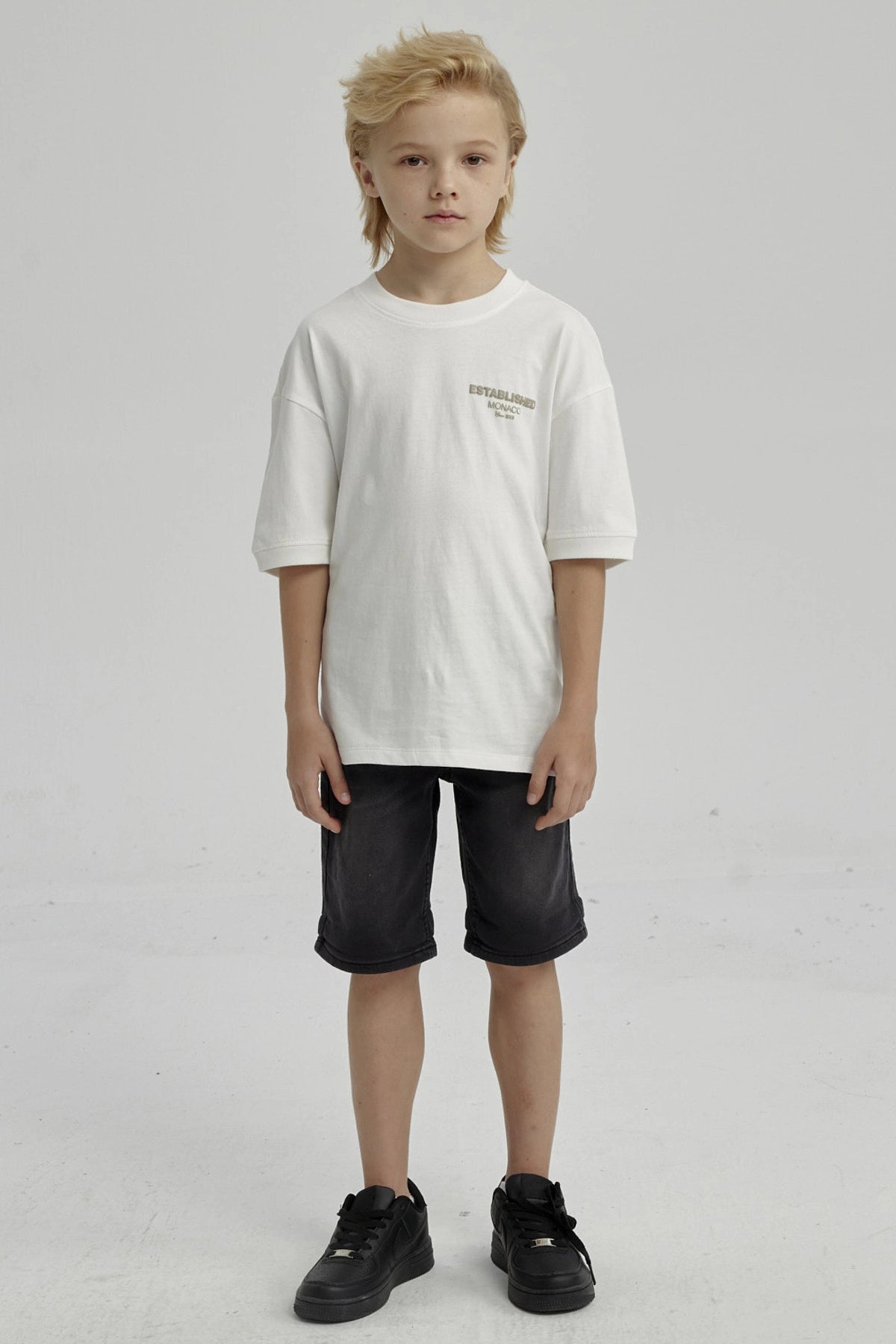 Polera de niño crudo con texto 'ESTABLISHED MONACO' en el pecho diseño sencillo y moderno de algodón sin estampa adicional