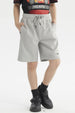 Bermuda niño gris melange con textura visible corte recto bolsillos laterales y pequeña etiqueta en el bajo izquierdo lisa