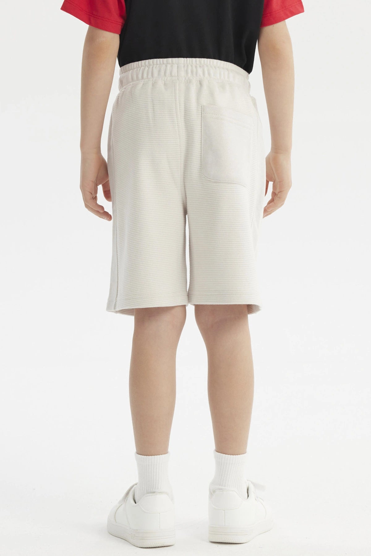 Bermuda niño color crudo con textura acanalada lisa ajuste con cordón y bolsillos laterales para estilo casual cómodo