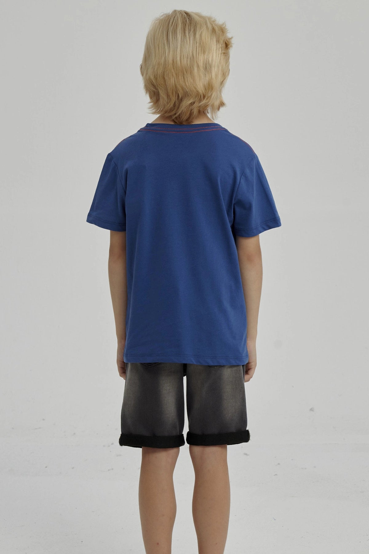 Polera azul para niño con bolsillo y estampado de pulpo naranja en el pecho pequeño y estilo caricatura