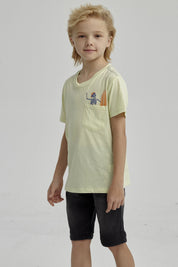 Polera amarilla para niño con bolsillo y estampa de esqueleto surfeando en estilo gráfico pequeño sobre el pecho