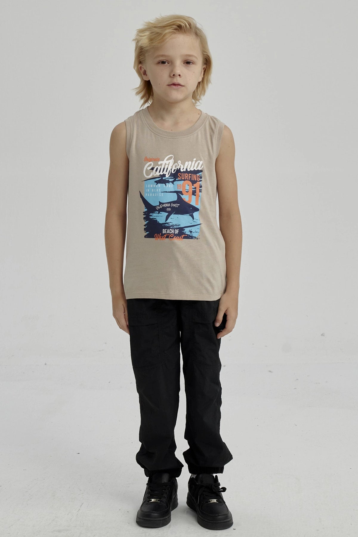 Polera sin mangas para niño color kaki con estampado grande de surf y tiburón en estilo gráfico playero California en el pecho