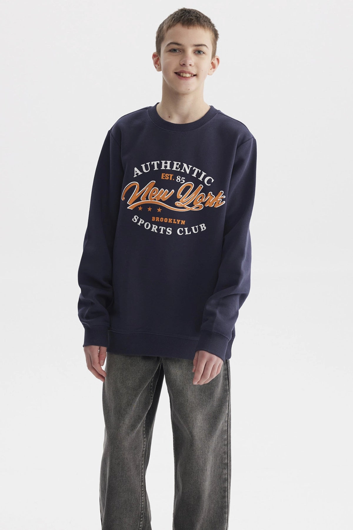 Polerón azul oscuro para niño con texto Authentic New York Sports Club en el pecho estilo casual urbano