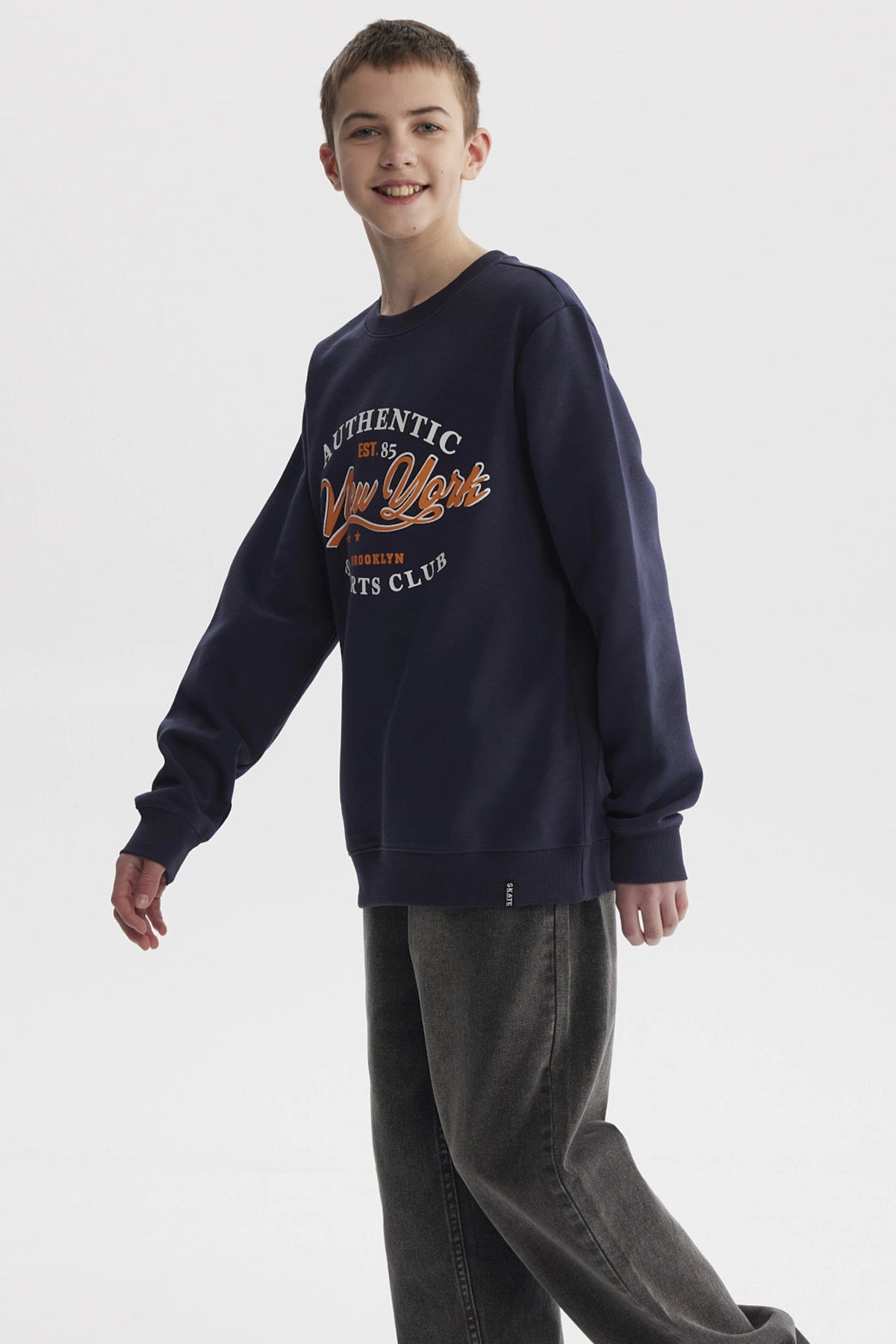 Polerón azul oscuro para niño con texto Authentic New York Sports Club en el pecho estilo casual urbano