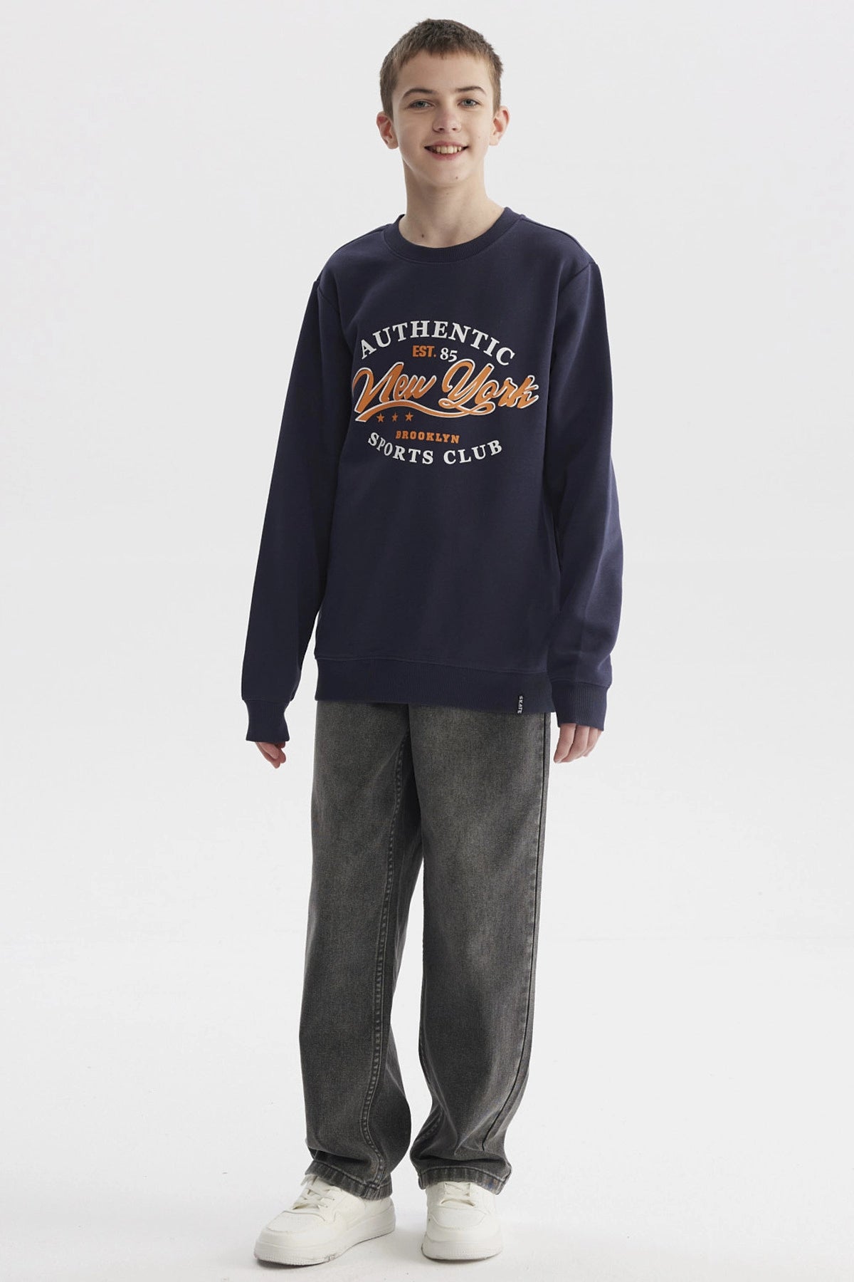 Polerón azul oscuro para niño con texto Authentic New York Sports Club en el pecho estilo casual urbano