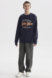 Polerón azul oscuro para niño con texto Authentic New York Sports Club en el pecho estilo casual urbano