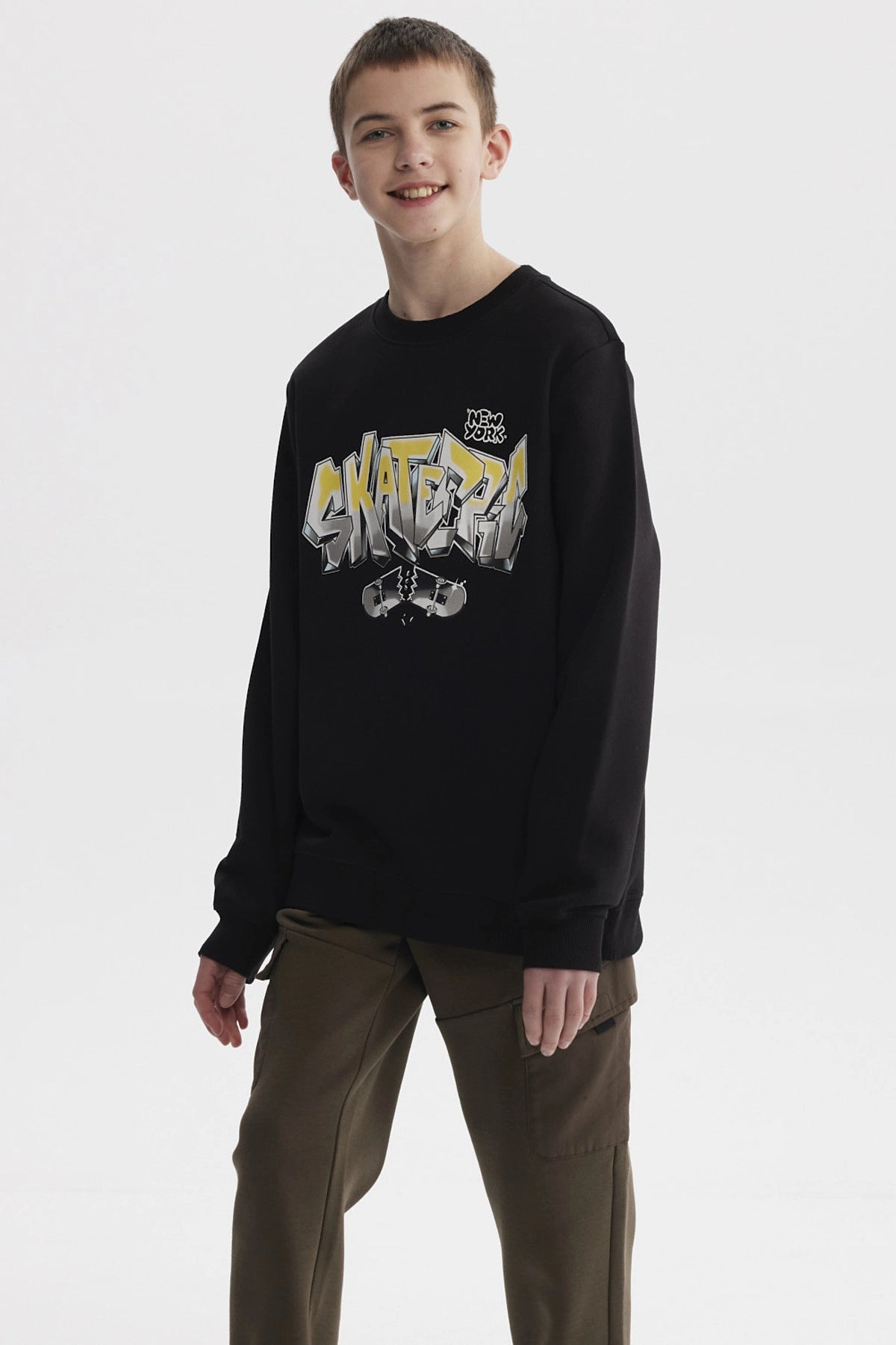 Polerón negro para niño con estampado SKATE en letras grandes estilo grafiti en el pecho con patineta rota