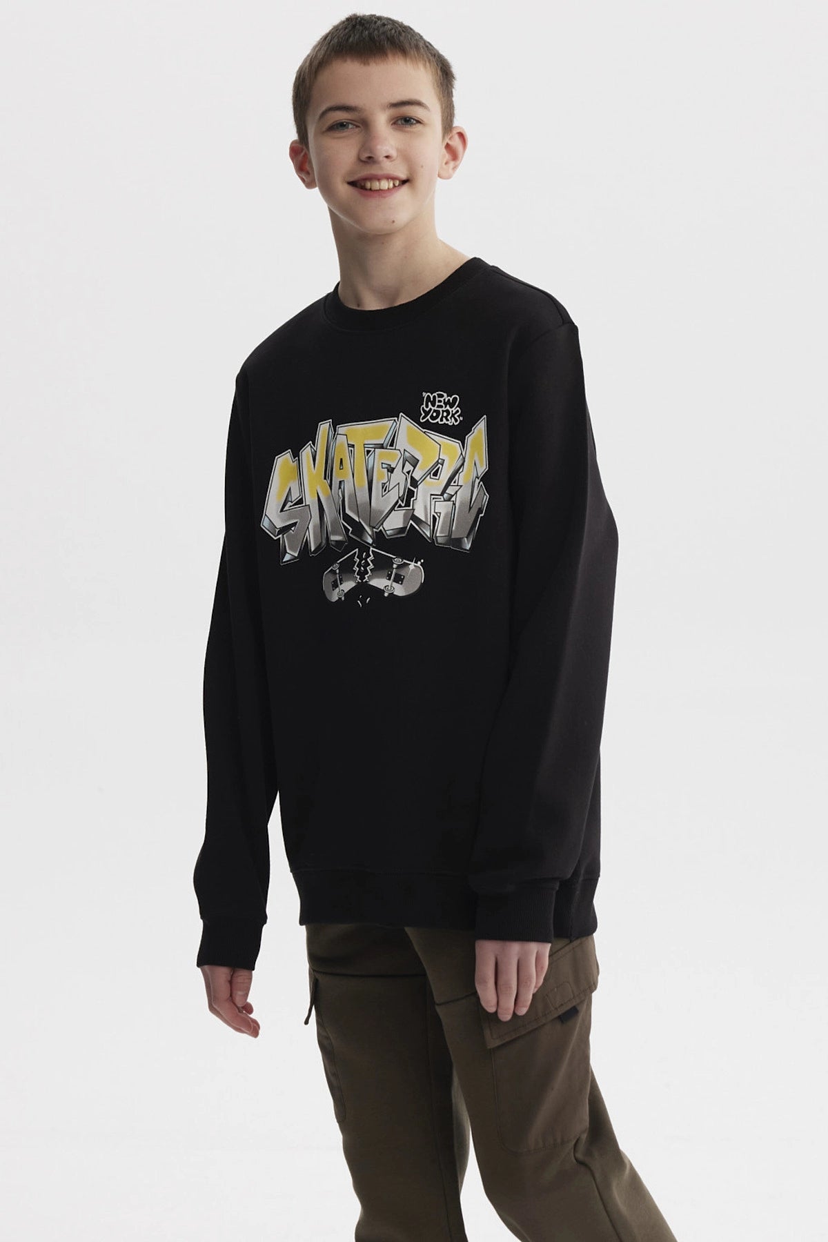 Polerón negro para niño con estampado SKATE en letras grandes estilo grafiti en el pecho con patineta rota